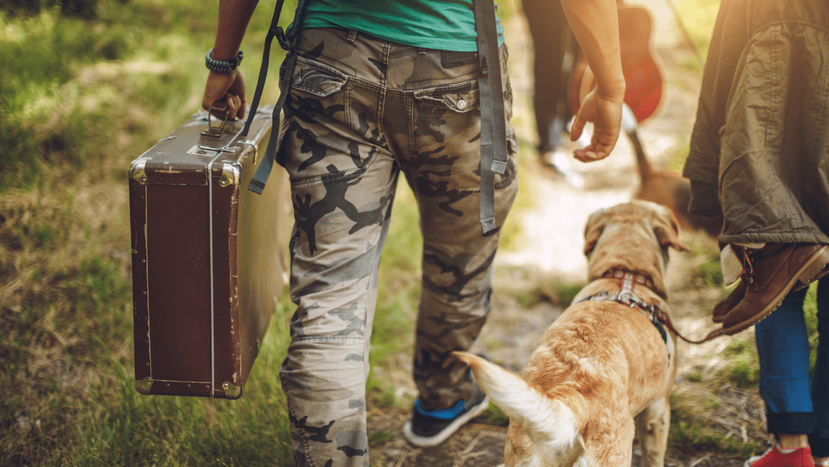 Man walking with Labrador with suitcase in and ready to go on holiday