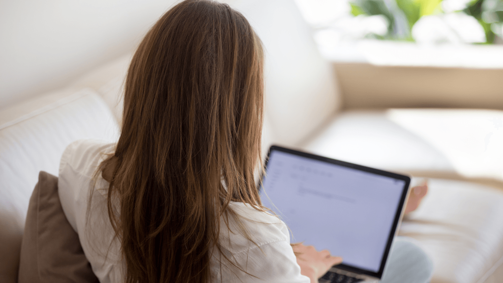 Focused woman typing on a laptop, creating engaging content for her blog.